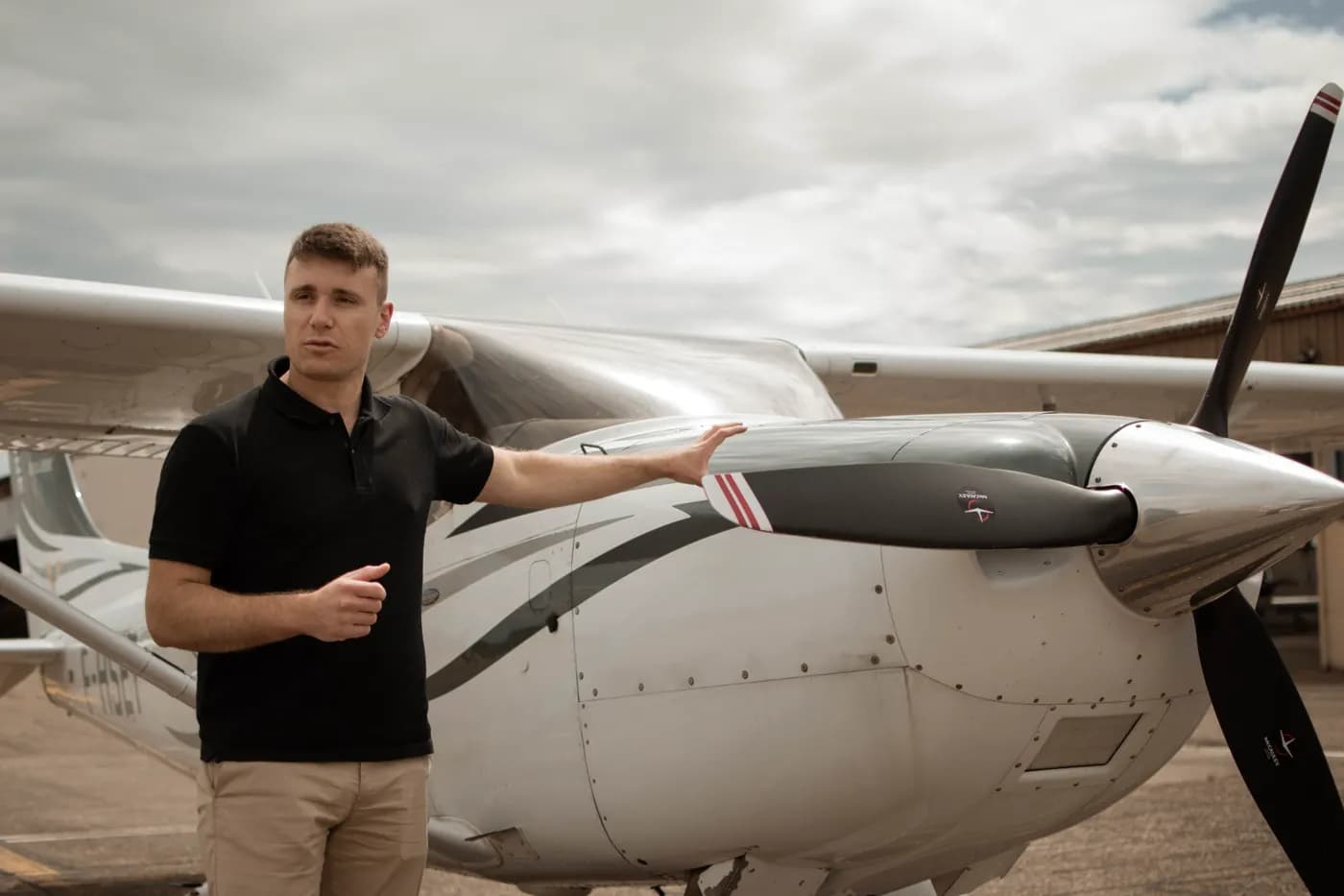 A briefing beside the propeller of a high-wing aircraft