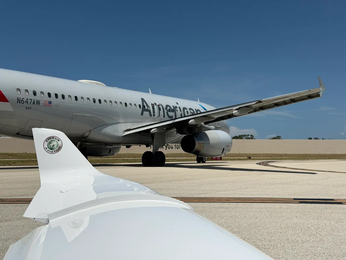 An airliner taxiing past, seen over a winglet