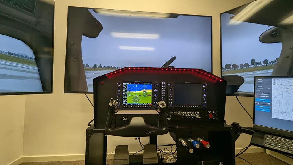 Le simulateur dans sa salle : poste Cessna et trois écrans affichant une piste